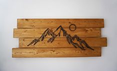 a wooden wall hanging with mountains on it