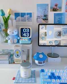 a desk with various items on it including a clock, keyboard, mouse and monitor