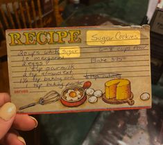 a person holding up a recipe card with eggs and bread on it in front of a table