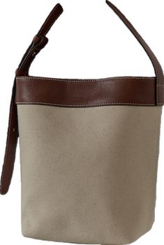 a canvas bag with brown leather handles