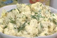 a white bowl filled with potato salad on top of a table