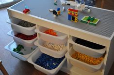 a toy kitchen with legos on the counter and food in bins under it