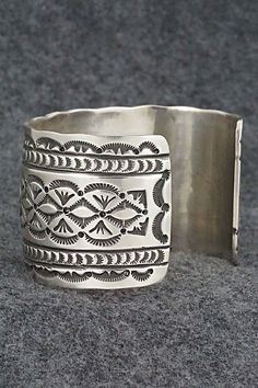 This stunning sterling silver bracelet was made by Navajo silversmith Leonard Maloney. The back is signed Maloney and stamped sterling.Size: 6" (will fit up to a 6 3/8" wrist)Gap: 1 3/8"Width: 1 3/4"Free shipping on all orders! We ship with USPS and always include tracking. All orders ship within a day of payment.Returns are accepted up to 30 days after you receive your order. Just send us a message. Our shop offers cash back or store credit. The item must be returned in new condition. Southwestern Silver Cuff Bracelet, Southwestern Engraved Sterling Silver Bracelet Gift, Untreated Sterling Silver Bracelet, Engraved Sterling Silver Bracelet Gift, Silver Untreated Cuff Bracelet Gift, Silver Artisan Bracelet, Bohemian Sterling Silver Engraved Bracelet, Engraved Sterling Silver Bohemian Bracelet, Adjustable Etched Sterling Silver Southwestern Bracelet