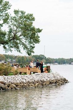 some people are standing on a dock by the water