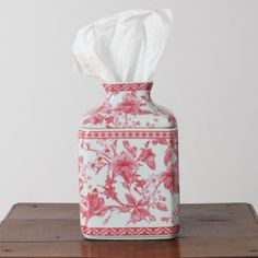 a tissue dispenser sitting on top of a wooden table