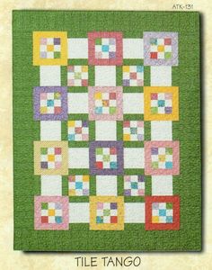 a quilted wall hanging with colorful squares on the front and back, in green grass