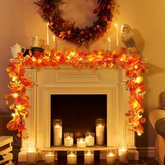 a fireplace decorated with candles and fall leaves