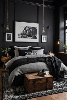 a bedroom with black walls and wooden flooring is pictured in this image, there are pictures on the wall above the bed