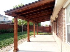 an outdoor covered patio area with grass and trees