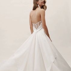 a woman in a white wedding dress looking back