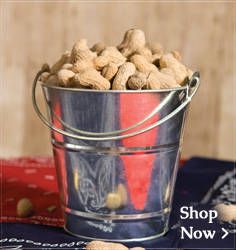 a bucket filled with peanuts sitting on top of a table next to a red and white cloth