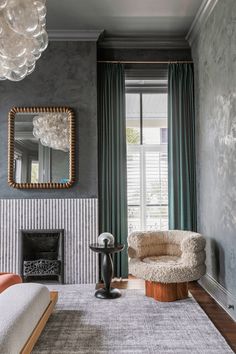 a living room with a chair, mirror and fireplace