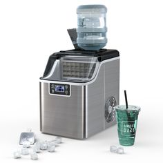 an ice cream maker with a cup next to it and several pieces of ice on the ground