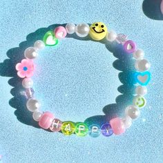 there is a bracelet made out of plastic beads with smiley faces and hearts on it