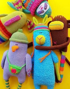 crocheted stuffed animals laying on top of each other with hats and scarves