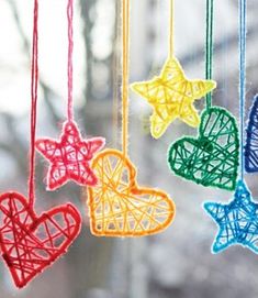 colorful string ornaments hanging from strings in the shape of hearts and stars