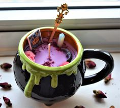 a cup filled with purple liquid next to a window