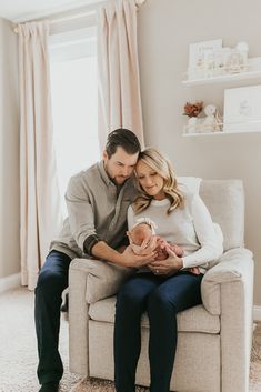 a man and woman sitting on a couch holding a baby