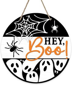 a wooden sign that says hey boo with ghost faces and spider webs on it