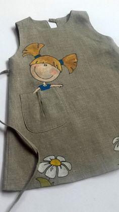 an image of a child's dress with flowers on the front and side, which is