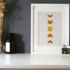 a white shelf topped with a framed photograph next to a vase filled with flowers