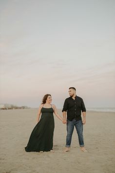 a man and woman holding hands on the beach