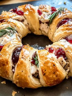 a cranberry and rosemary roll is shown on a baking sheet, ready to be baked