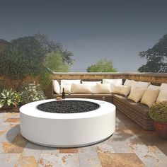 an outdoor living area with couches, tables and potted plants