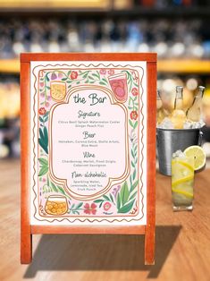 the menu is displayed on a wooden table next to a glass with lemonade and ice