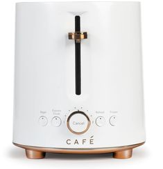 a white toaster sitting on top of a wooden table next to a black and gold handle