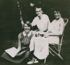 an old black and white photo of three women sitting in lawn chairs smiling at the camera