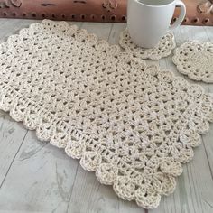 a crocheted placemat and coffee cup on a table