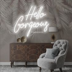 a grey chair sitting in front of a wall with a neon sign that says hello gorgeous