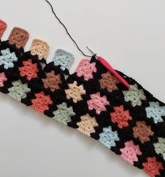 a crocheted piece of cloth with an electric hook attached to it and several different colored stars on the side