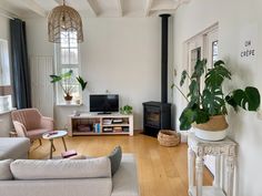 a living room filled with furniture and a flat screen tv on top of a wooden floor