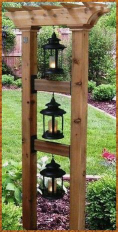 a wooden structure with lanterns hanging from it's sides in the middle of a garden