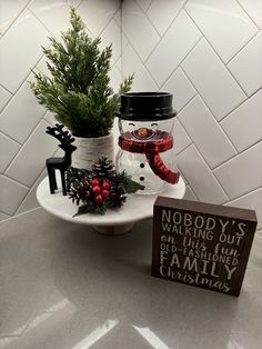 a snowman jar with christmas decorations and a sign that says nobody's waiting out