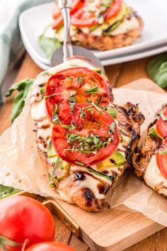 grilled chicken with tomatoes and mozzarella on a cutting board