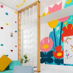 a room with colorful wallpaper and climbing ropes on the walls is decorated with flowers