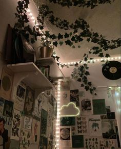 a room with many pictures and lights on the walls, including plants hanging from the ceiling