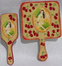 two decorative plates with cherries on them and one has a woman sitting on it