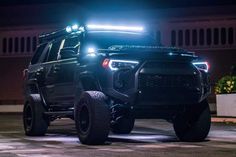 a black truck is parked on the street at night