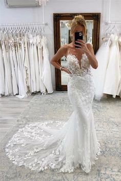 a woman is taking a selfie in front of her wedding gowns and dresses