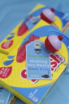 two boxes of candy sitting on top of a blue cloth covered tablecloth with tags attached to them