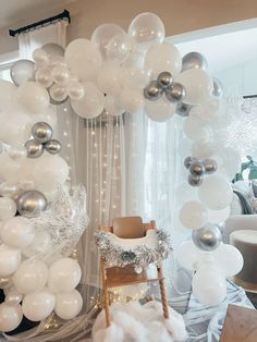 white and silver balloons are hanging from the ceiling