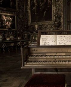 an old piano in a room with paintings on the wall