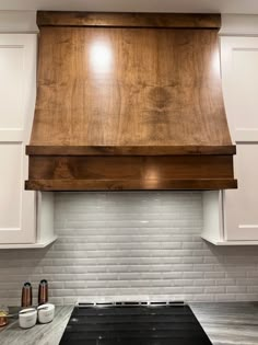 a stove top oven sitting inside of a kitchen next to white cabinets and counter tops