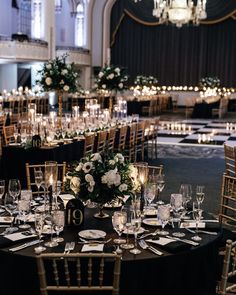 the tables are set for an event with candles and centerpieces on each table