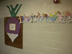 a group of paper dolls hanging from the side of a wall