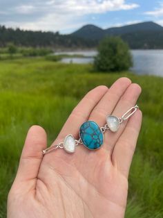 DETAILS: Metal : Sterling Silver 925 Cabochons : Moon River Turquoise & Grey Moontone Stone Color : Blue and GreyChoker Length: Adjustable 12-16 inches Turquoise: 20 x 25 mm Grey Moonstone: 10.5 x 15.5 mm DESCRIPTION: This handmade choker necklace features a stunning 13 carat center Moon River Turquoise flanked by 4 carat Fancy Grey Moonstones on each side. This unique combination of rare stones creates a truly one of a kind piece. With an entirely hand-made chain which includes thick 16 gauge round wire links, this choker is adjustable from 12 to 16 inches for the perfect fit. HEALING PROPERTIES: Turquoise was once the stone of kings and warriors. It protects during any kind of travel. It is a stone that brings balance and help us solve problems as it empowers us with our own self belief. Handmade Choker Necklace, Turquoise Grey, Handmade Chokers, Moon River, Rare Stone, Moon Stone, Jewelry Care, Stone Color, Moonstone